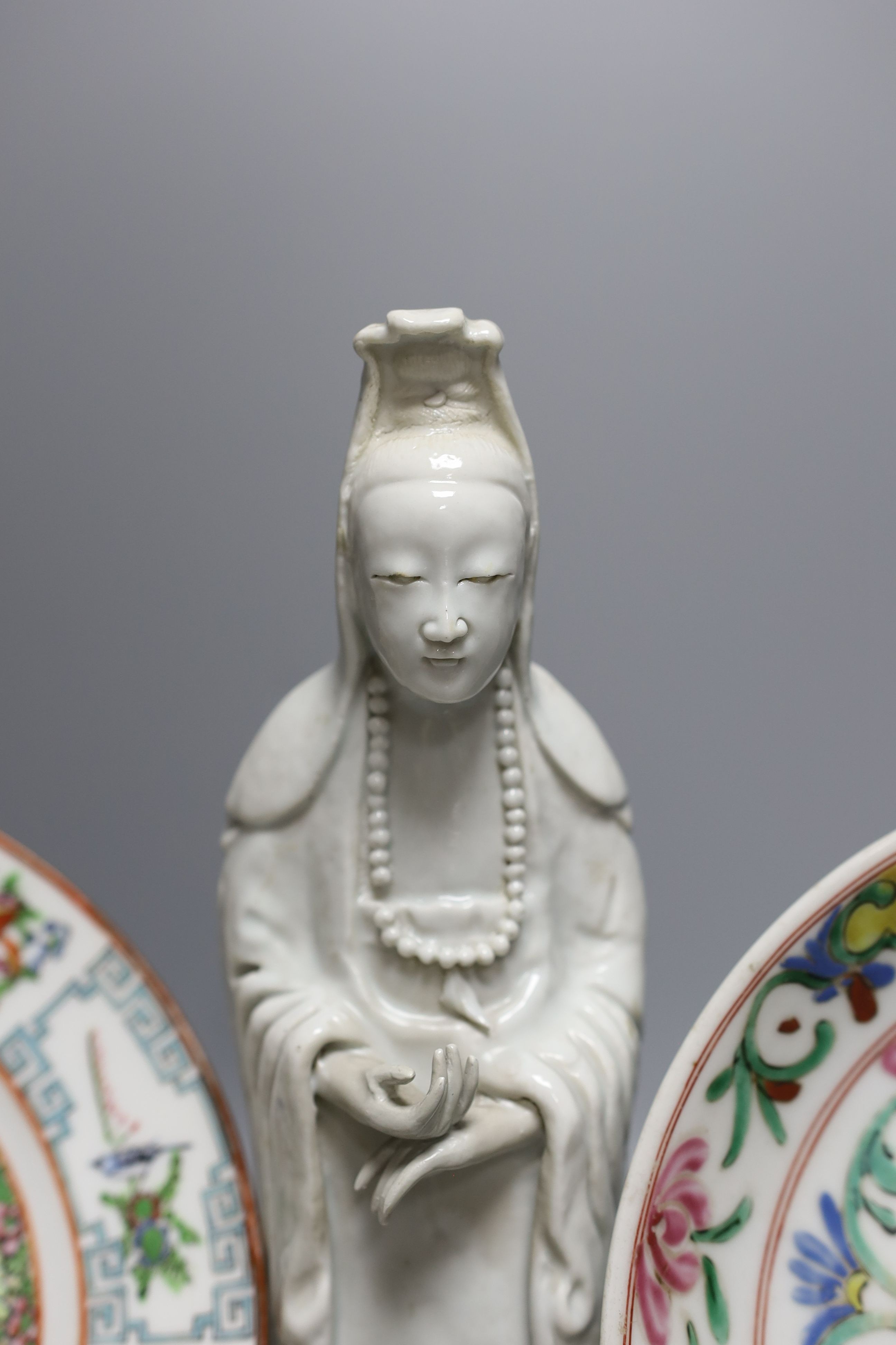 A Chinese blanc de chine figure of Guanyin, probably 18th century and two famille rose plates. Tallest 26cm